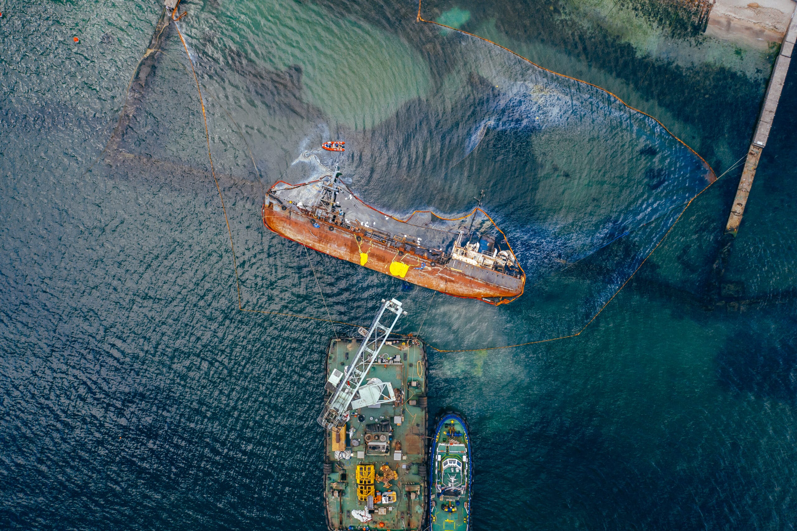 Aerial view of an old tanker overturned on the shore, illustrating potential seabed mining environmental impact near the coas